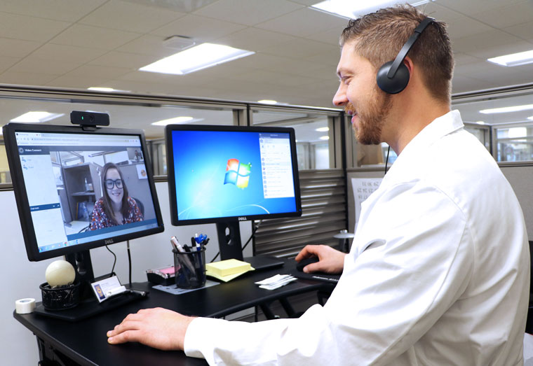 A nurse practitioner talks with a nurse over the VA Video Connect application on the computer.