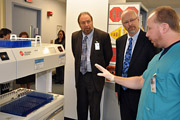 Mr. Moreland and Mr. Cox, Medical Center Director, receive a demonstration of the new fully automated laboratory system from Frank Viani, Laboratory Technician.