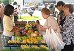 Shoppers and vendors shop at an Erie VA farmers' market.