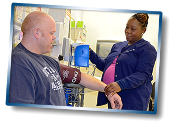 A nurse measures the blood pressure of a Veteran during a clinic appointment.