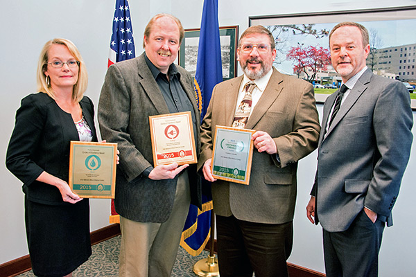 Leadership from Erie VA Medical Center display thier Emerald award plaques.