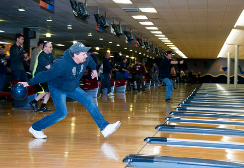 A Veteran getting ready to roll a ball at a bowling alley.