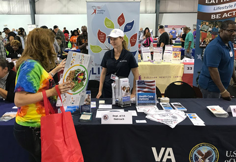 A female Veteran talks with VA staff at the stand down event.