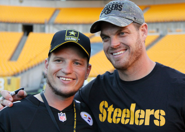 A Veteran poses for a photo with a Steelers player.