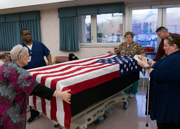 Honors escorts practice the proper way to display a U.S. flag over a patient gurney.