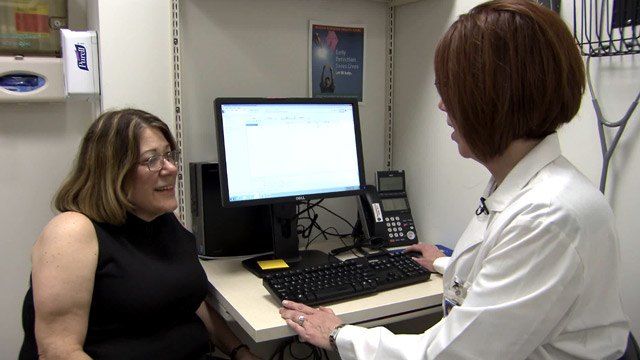 A female Veteran talks to her physician during an office visit.