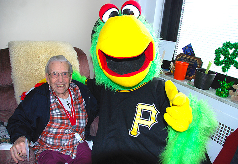 A Veteran poses for a photo with the Pittsburgh Pirates Parrot mascot.